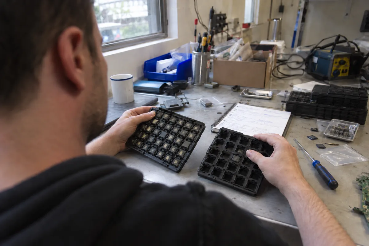 A technician comparing generic electronics parts during component research.