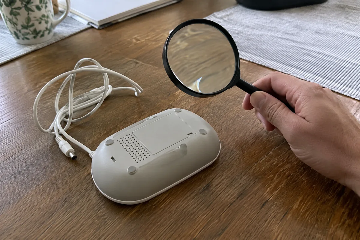 An analyst pausing inspection beside a face-down parent unit and loose cable